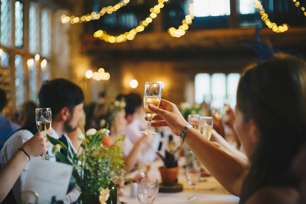 Happy people raising glasses in celebration at a wedding reception, PST Trolley Corporate Events