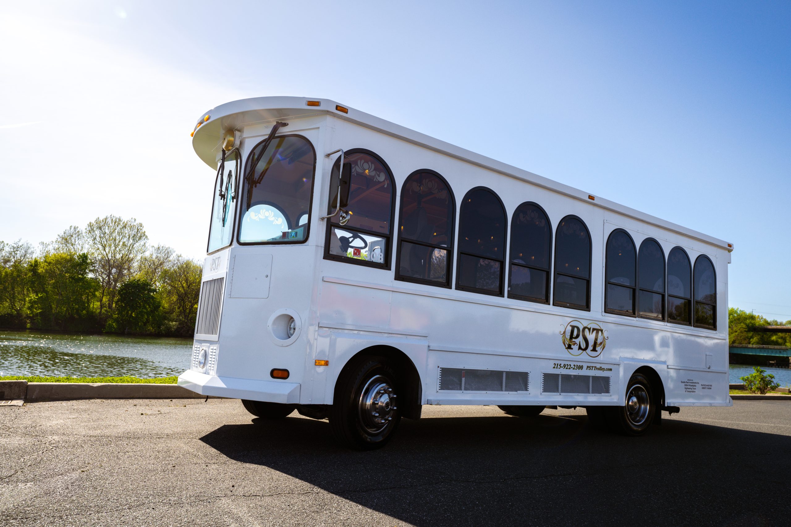 Outdoor view of a PST 23-passenger trolley parked in a natural setting, showcasing its size and design.