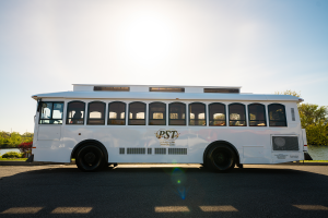 White bus parked by serene body of water - PST Trolley