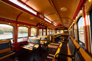 A bus with numerous seats and a window - PST Trolley