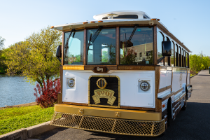 White bus parked in front of scenic body of water - PST Trolley