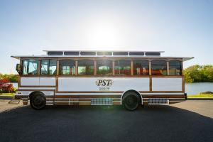 White bus parked in front of calm body of water - PST Trolley