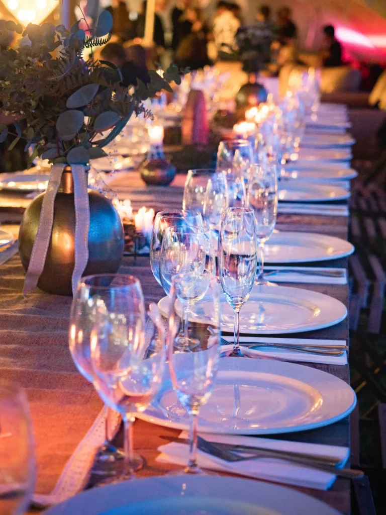 a long table is set with wine glasses